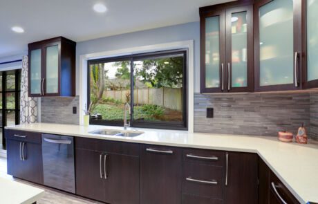 Updated contemporary kitchen room interior in white and dark tones.